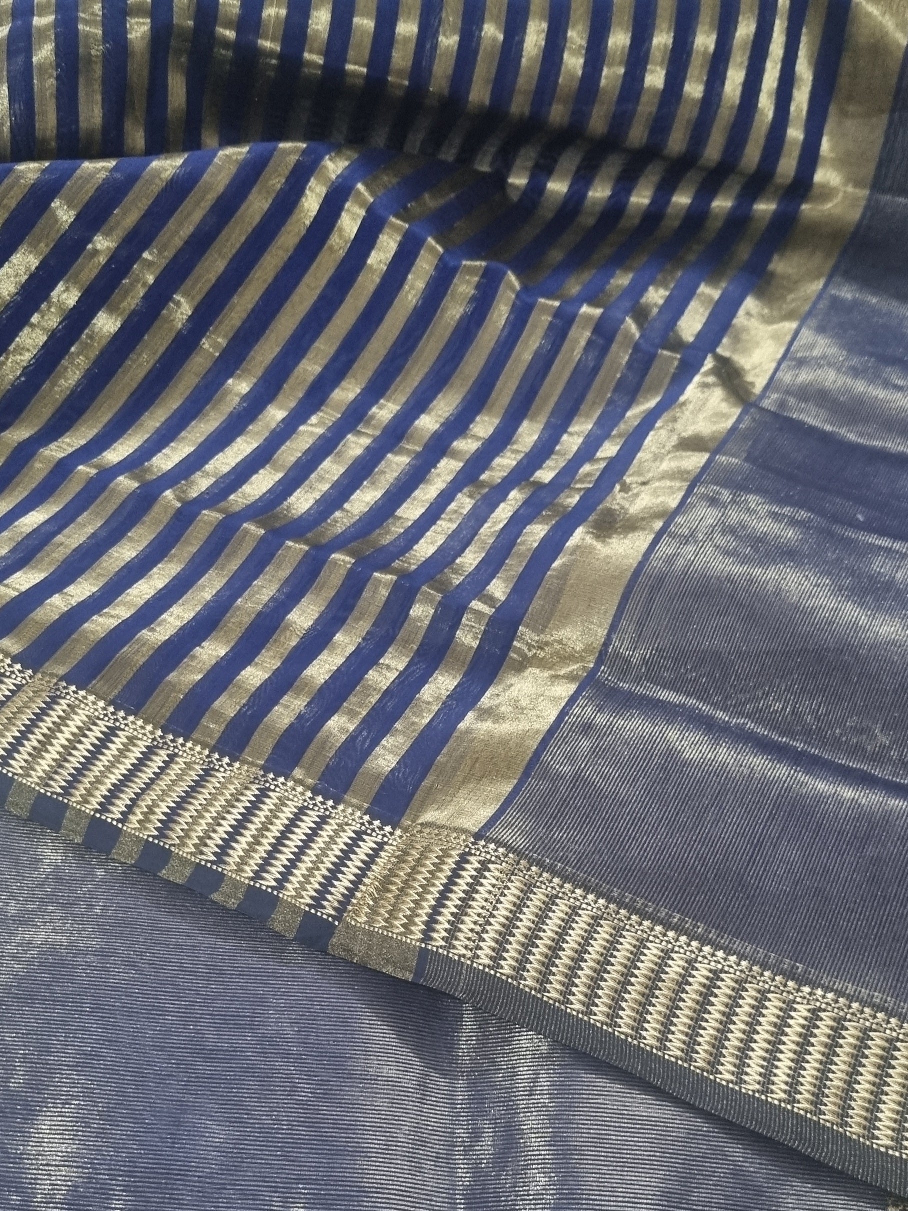 Close-up of royal blue Maheshwari handwoven silk fabric with gold Zari border and motifs