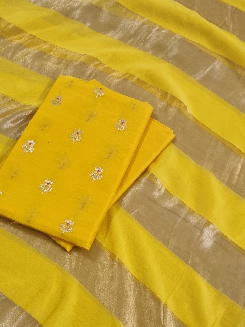 Flat lay of yellow Banarasi unstitched suit set — Karwa Booti handwoven Indian handloom fabric