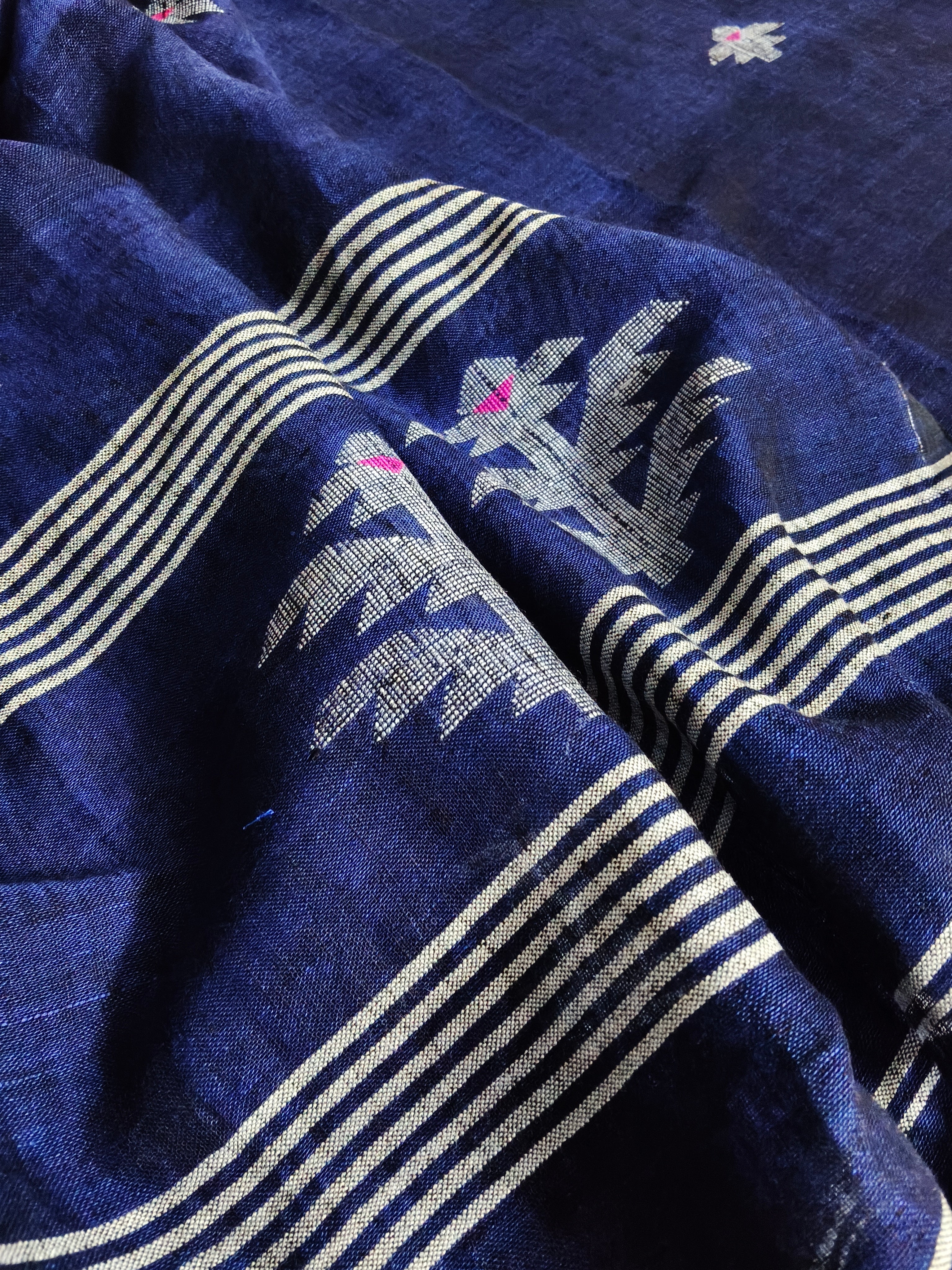 Deep indigo blue handloom linen fabric with traditional woven motifs – close-up texture detail, unstitched suit material
