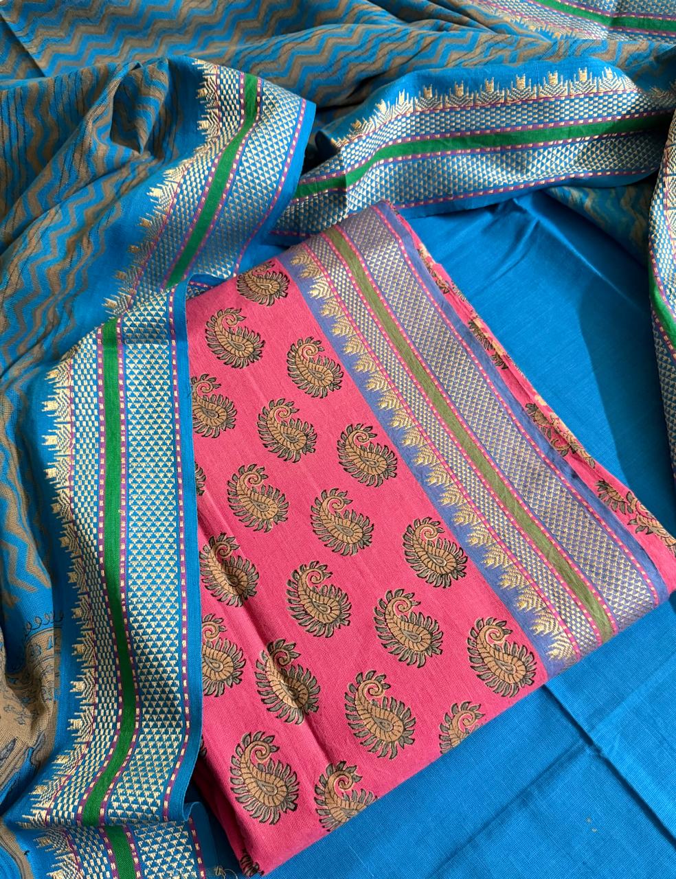 Blue and pink handloom cotton unstitched suit set flat lay — pink kurta fabric with gold paisley woven motifs, blue bottom, and blue dupatta with woven temple border and zigzag pattern