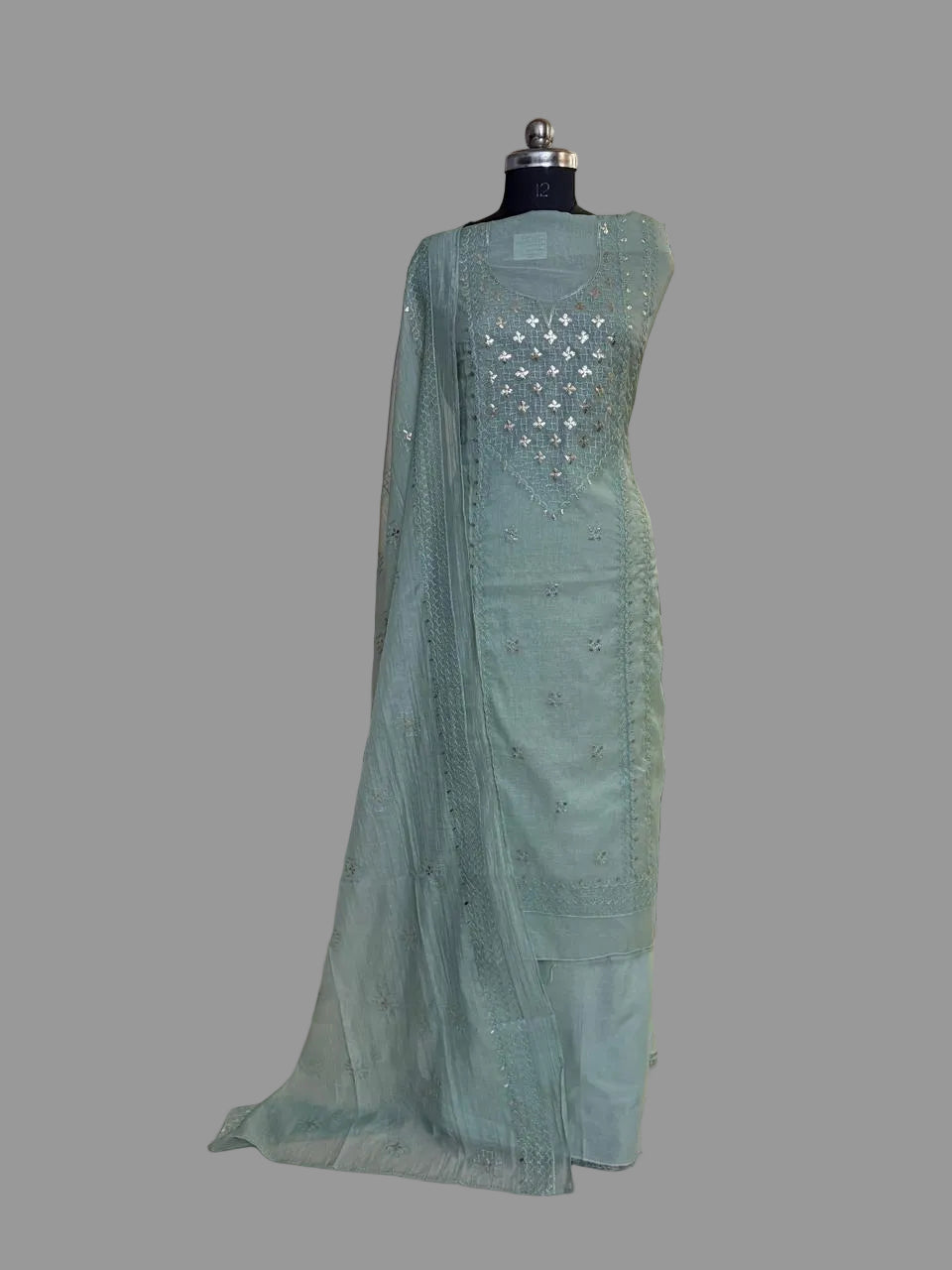Powder green Chanderi silk 3-piece unstitched suit set with pita work embroidery and silver sequin detailing, draped on mannequin
