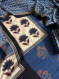 Close-up of blue and black Ajrakh cotton kurta with cream yoke panel featuring bold blue and red lotus floral block print, black border, and indigo blue dupatta with white zigzag chevron print
