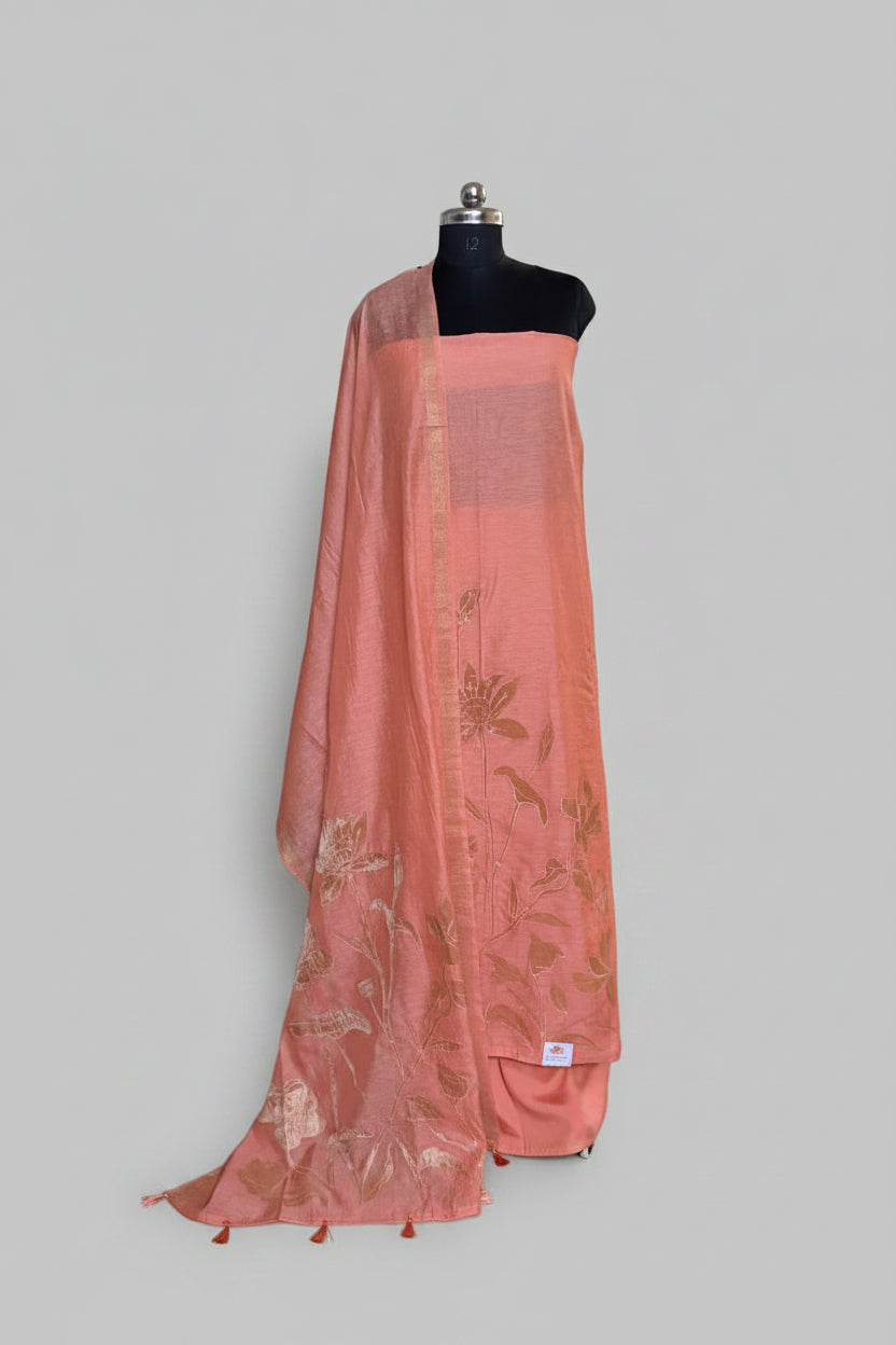 Peach beige Chanderi silk 3-piece unstitched suit set on mannequin with gold appliqué floral dupatta draped over shoulder and tassel trim