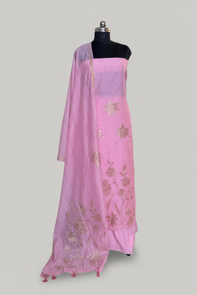 Pink Chanderi silk 3-piece unstitched suit set on mannequin with gold appliqué floral dupatta draped over shoulder and tassel trim