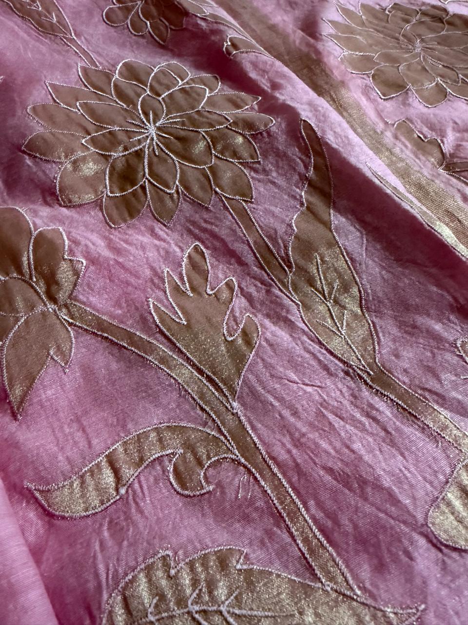 Close-up of pink Chanderi silk dupatta with gold appliqué dahlia and botanical floral motifs on shimmering fabric