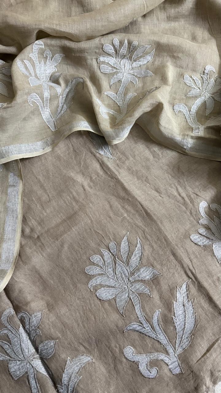 Close-up of taupe linen kurta fabric with scattered white silk tissue appliqué botanical and floral motifs