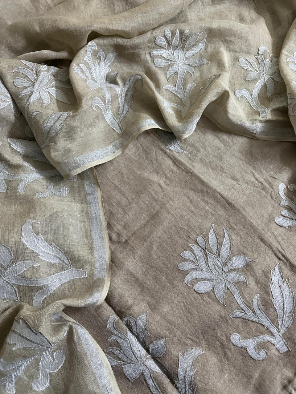 Taupe linen unstitched suit fabric with white silk tissue appliqué floral and leaf motifs, dupatta and kurta pieces laid flat