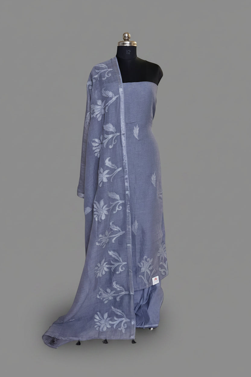 Grey linen 3-piece unstitched suit set on mannequin with silver silk tissue appliqué floral dupatta draped over shoulder and tassel trim