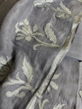 Grey linen unstitched kurta fabric with silver silk tissue appliqué floral and leaf motifs, dupatta border visible alongside