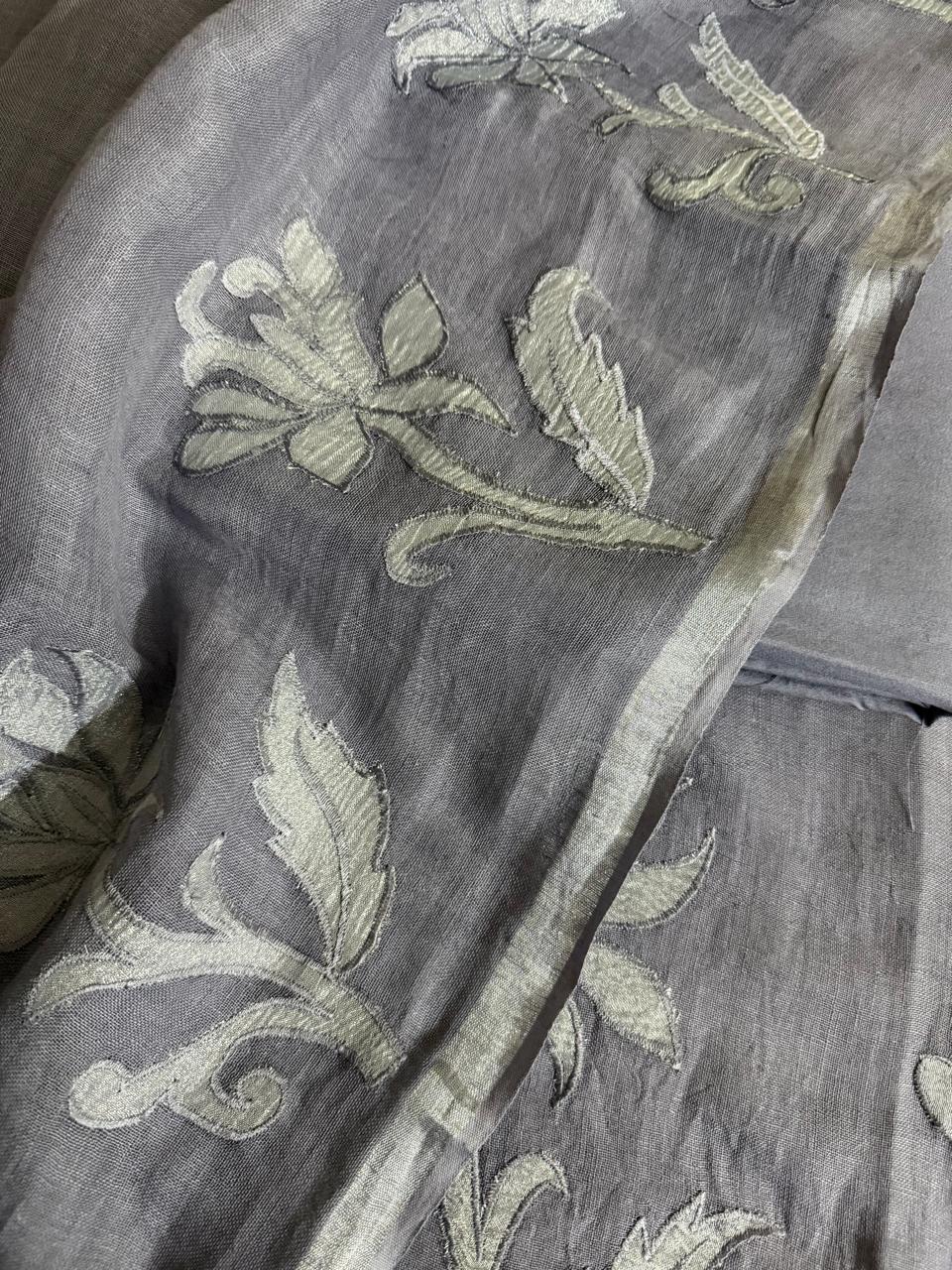 Grey linen unstitched kurta fabric with silver silk tissue appliqué floral and leaf motifs, dupatta border visible alongside