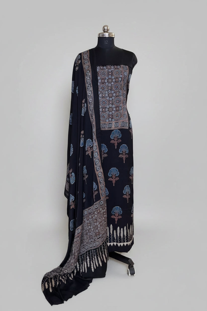 Black Ajrakh Modal silk 2-piece kurta dupatta set on mannequin with blue geometric medallion yoke, scattered glory lily body print and white fern border dupatta

