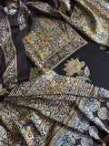 Flat lay of black modal silk Ajrakh kurta dupatta set showing blue and gold medallion yoke panel, scattered lotus body print and intricate paisley dupatta border