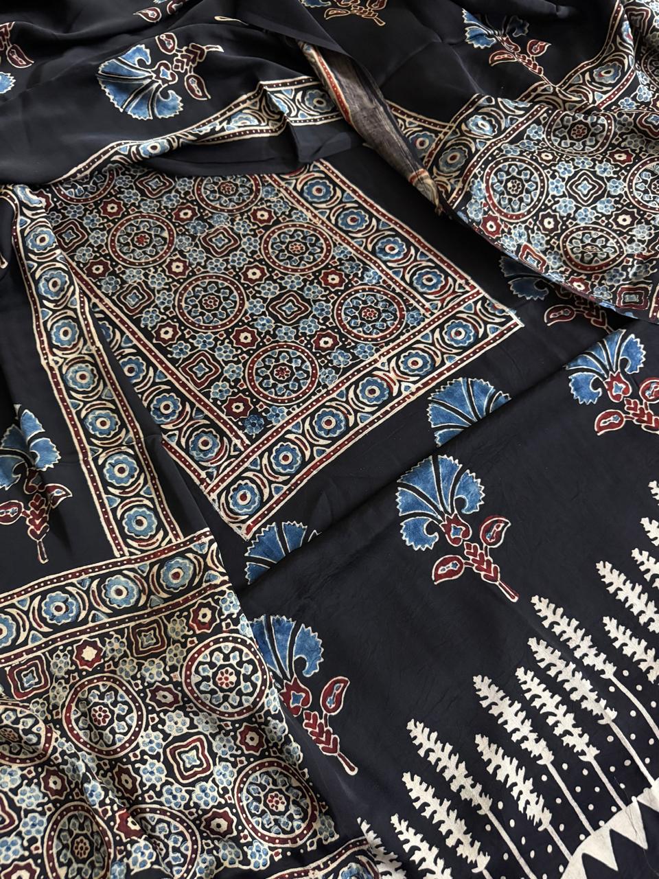 Close-up of black Ajrakh Modal silk kurta dupatta set showing blue geometric medallion yoke panel, glory lily body print and white fern leaf dupatta border