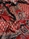 Flat lay of red and black Ajrakh Modal silk kurta dupatta set showing red body with scattered floral sprigs, black arch lotus panel border and intricate dupatta
