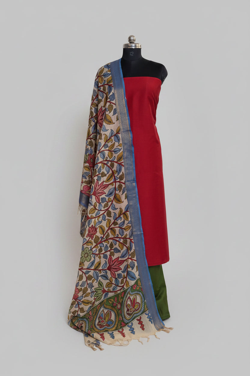 "Mannequin display of 3-piece unstitched suit set – crimson red cotton silk kurta with hand-painted Pen Kalamkari dupatta draped over shoulder, forest green bottom visible"