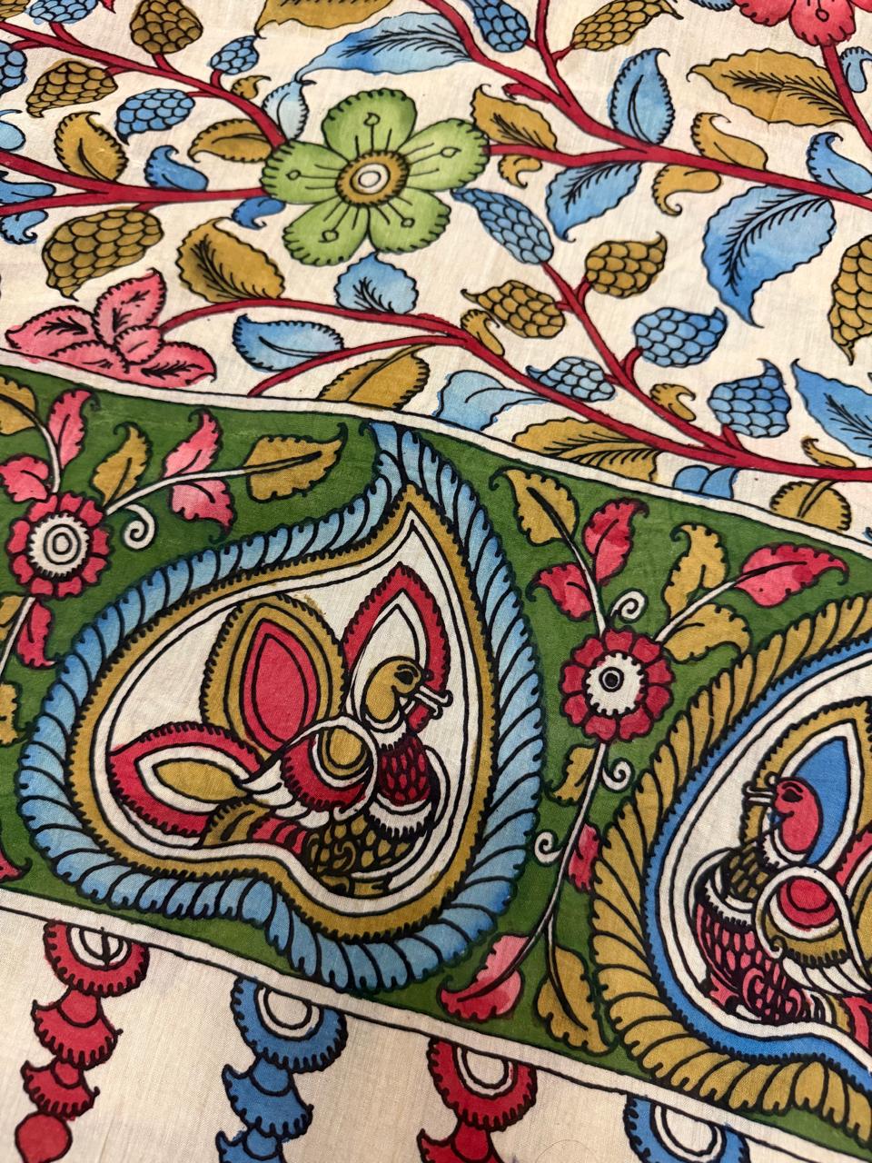 Macro detail of Pen Kalamkari dupatta border – hand-painted peacock pair in teardrop medallion on green ground, floral vine body above, Mangalgiri pattu silk