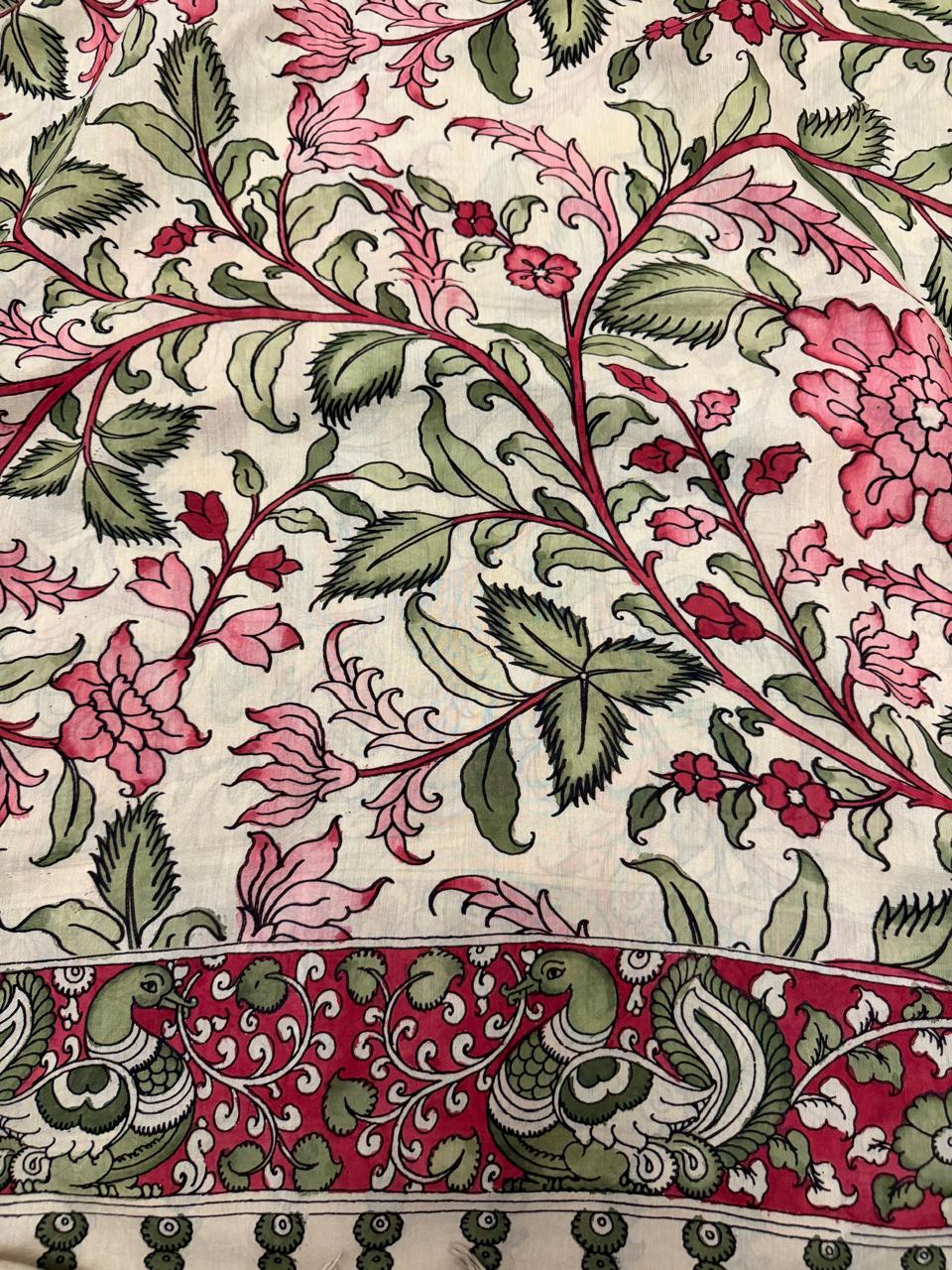 Close-up of hand pen Kalamkari dupatta body – dense pink and crimson floral vine with multi-petal blooms and forest green leaves on ivory ground, peacock-pair on crimson border below, Mangalgiri silk