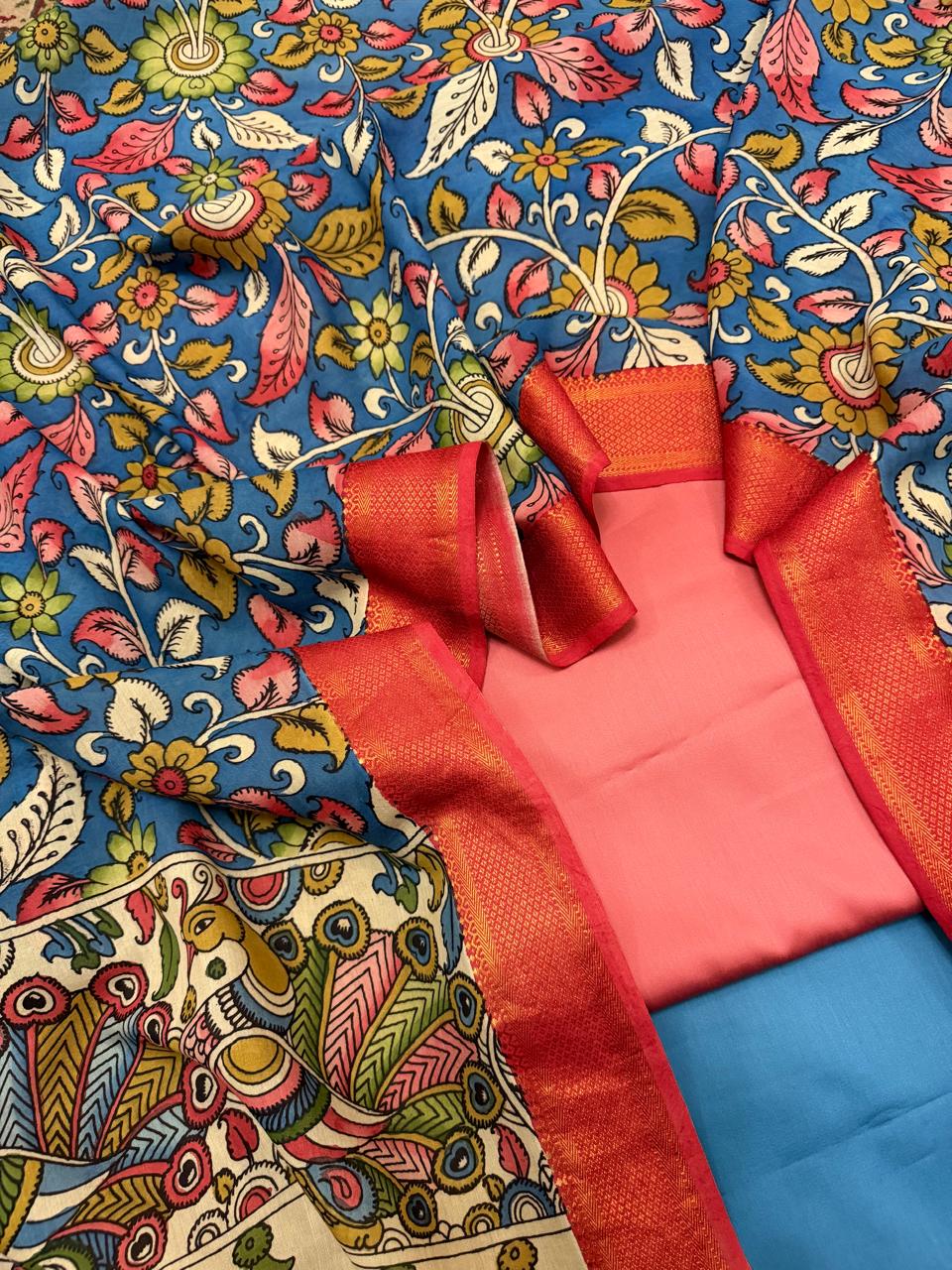 Hand painted Kalamkari dupatta with rose pink and slate blue cotton silk 3-piece unstitched suit set – flat lay overview showing blue floral body and ivory peacock pallu, House of Tantuvana
