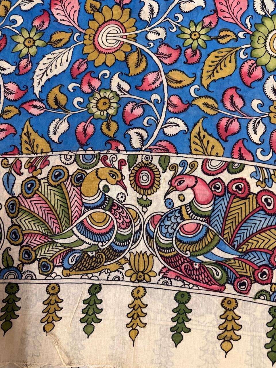 Macro detail of hand painted Kalamkari dupatta ivory peacock-pair pallu – two facing peacocks with multicolour pink and gold plumage on ivory ground, green tassel drops below, cobalt blue floral body