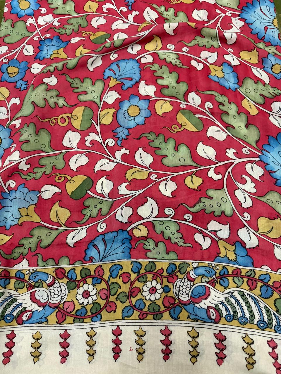 Full body detail of hand pen Kalamkari dupatta – dense blue daisy and green foliage vine on crimson red Mangalgiri silk, yellow-gold peacock-pair border below with floral scroll and tassel fringe