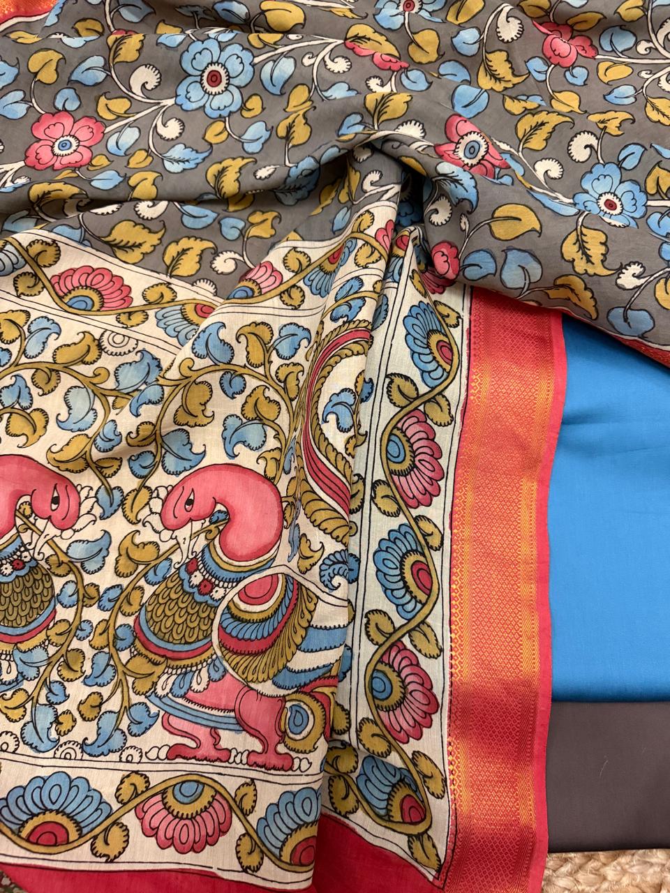 Draped close-up showing transition from grey floral body to ivory peacock pallu of hand painted Kalamkari dupatta – pink peacock motif, red-orange Zari border edge, state blue cotton silk below