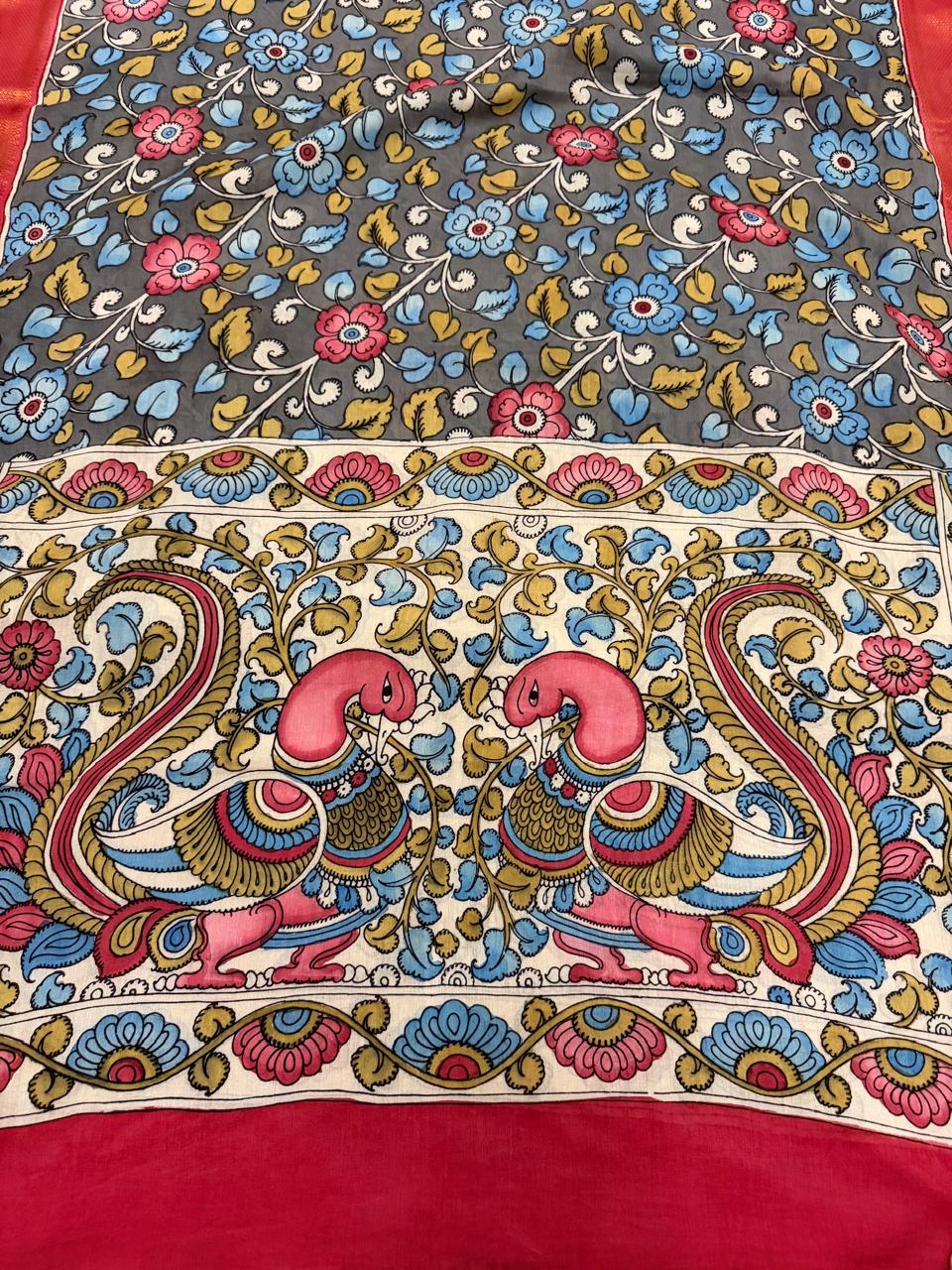 Full pallu detail of hand painted Kalamkari dupatta – facing peacock-pair on ivory ground with blue and gold scrolling foliage, grey floral vine body above, red-orange Zari border and red border below