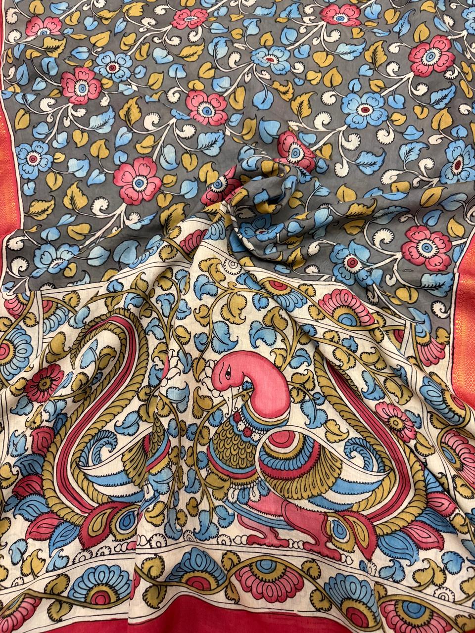 Draped dupatta showing grey floral body and ivory peacock pallu of hand painted Kalamkari – pink and crimson peacock motif with blue and gold foliage scrollwork, red-orange Zari border, Mangalgiri silk