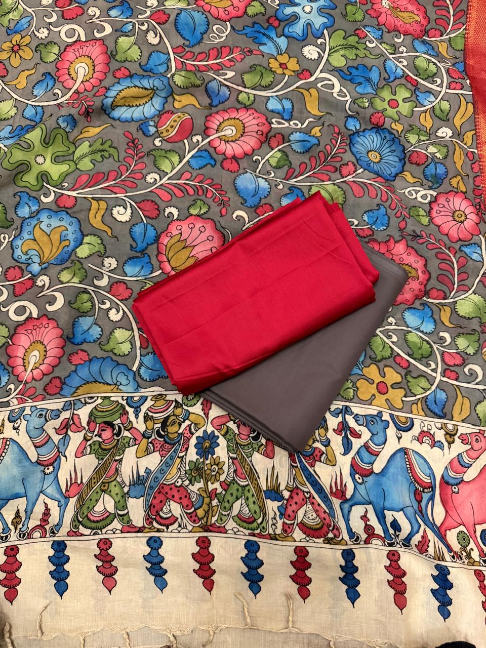 Close-up of hand painted Kalamkari dupatta body and Zari border alongside red cotton silk – grey ground multicolour floral vine with pink lotus and blue blooms, red-gold Zari edge, charcoal grey bottom