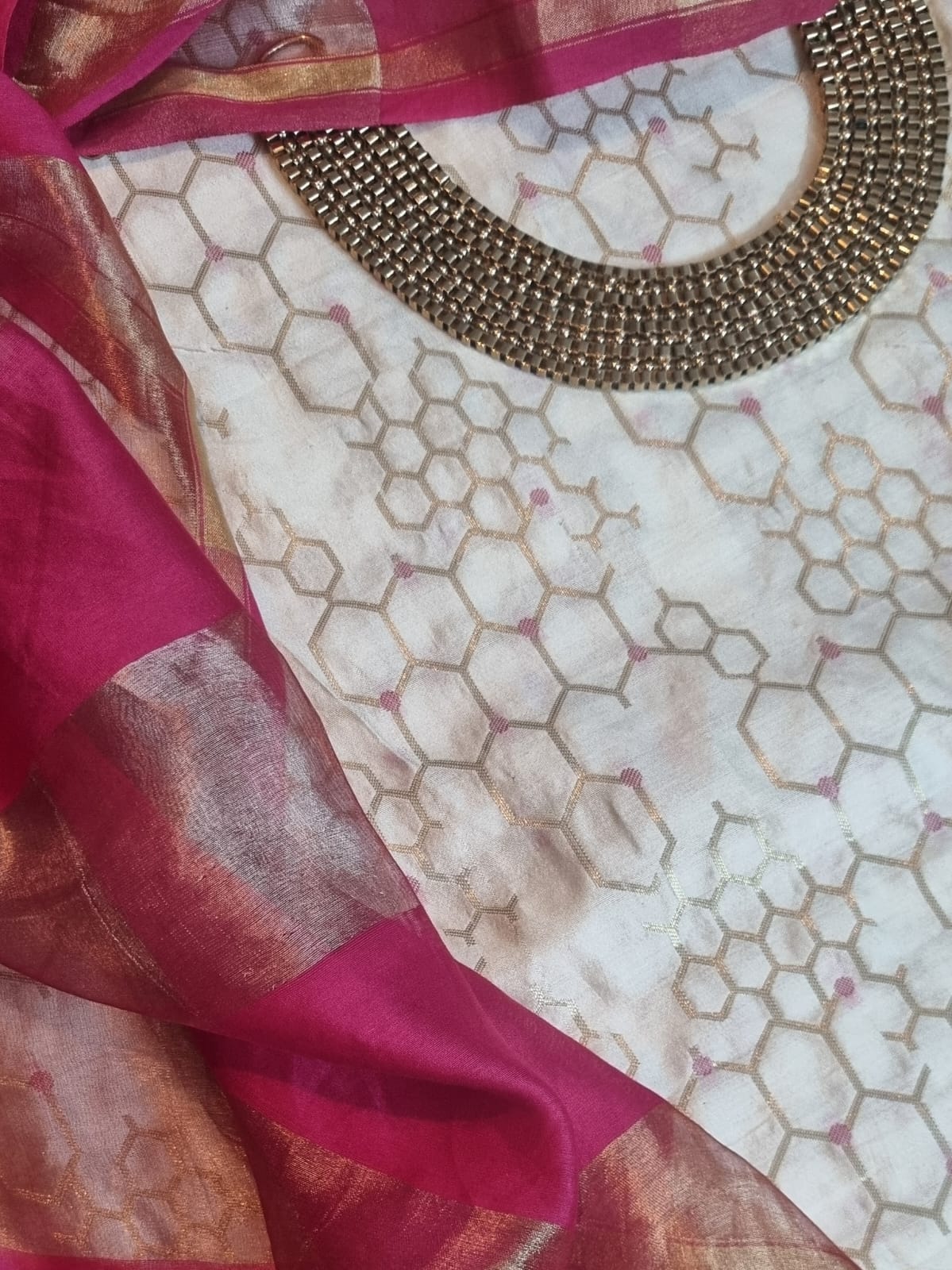 Close-up of cream and pink Banarasi unstitched suit fabric with intricate weave detail