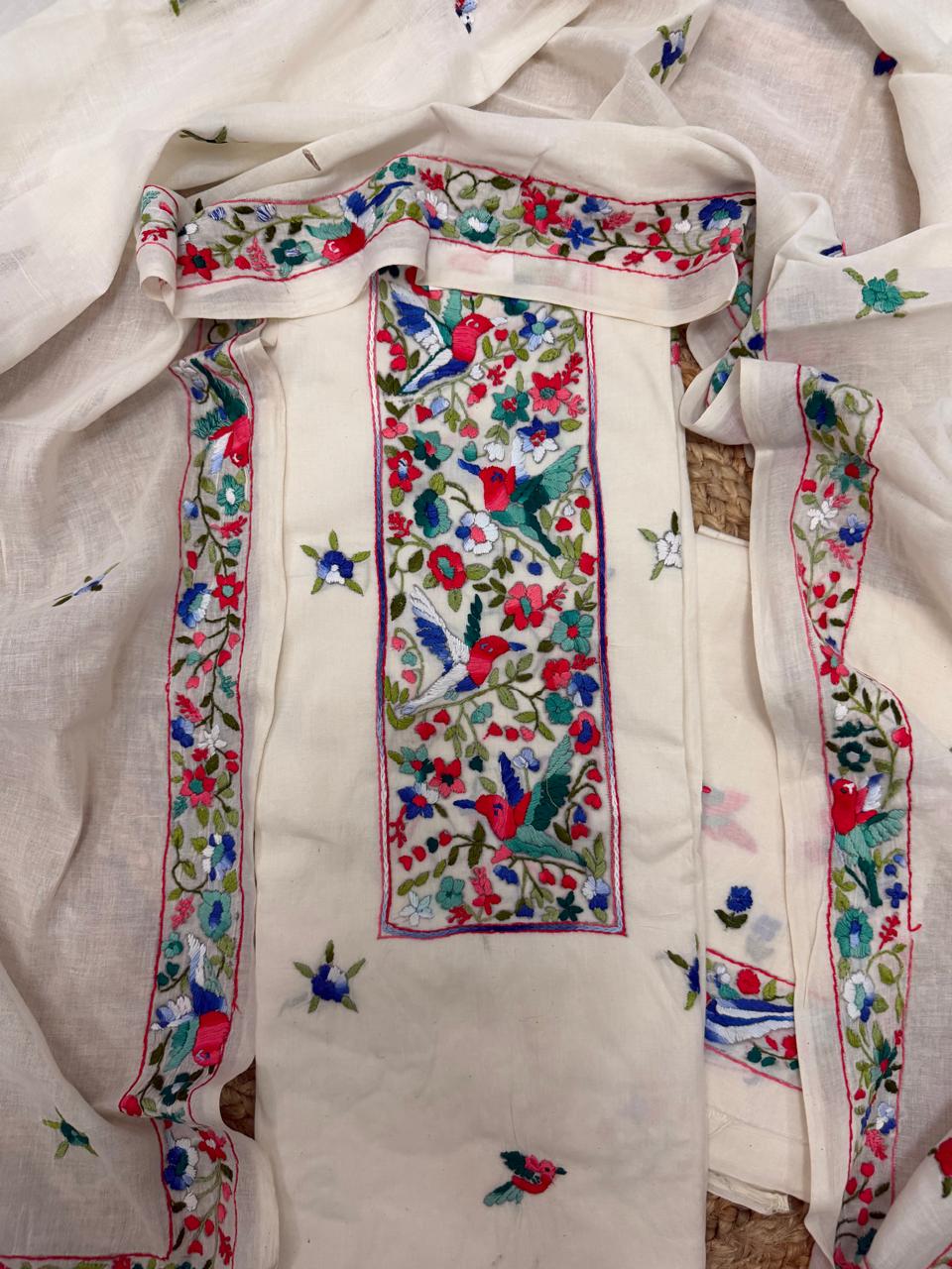 Straight flatlay of cream cotton Sindhi hand-embroidered kurta – bold red and green geometric neckline panel with all-over diamond butti, unstitched 3-piece suit se