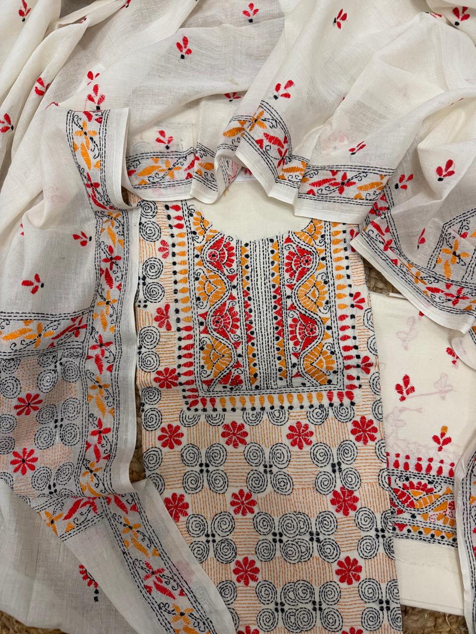 Cream cotton Kantha work kurta fabric flatlay – dense multicolour embroidery with red and mustard floral neckline panel, spiral body motifs and scattered butti on dupatta