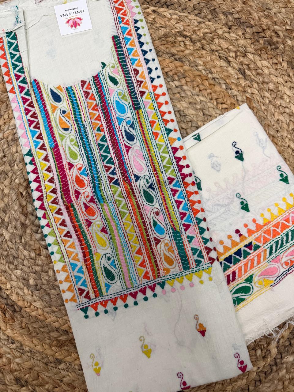 Straight flatlay of white cotton Kantha hand-embroidered kurta with multicolour striped paisley neckline panel, paired with plain white bottom fabric with scattered butti, unstitched co-ord set on jute surface