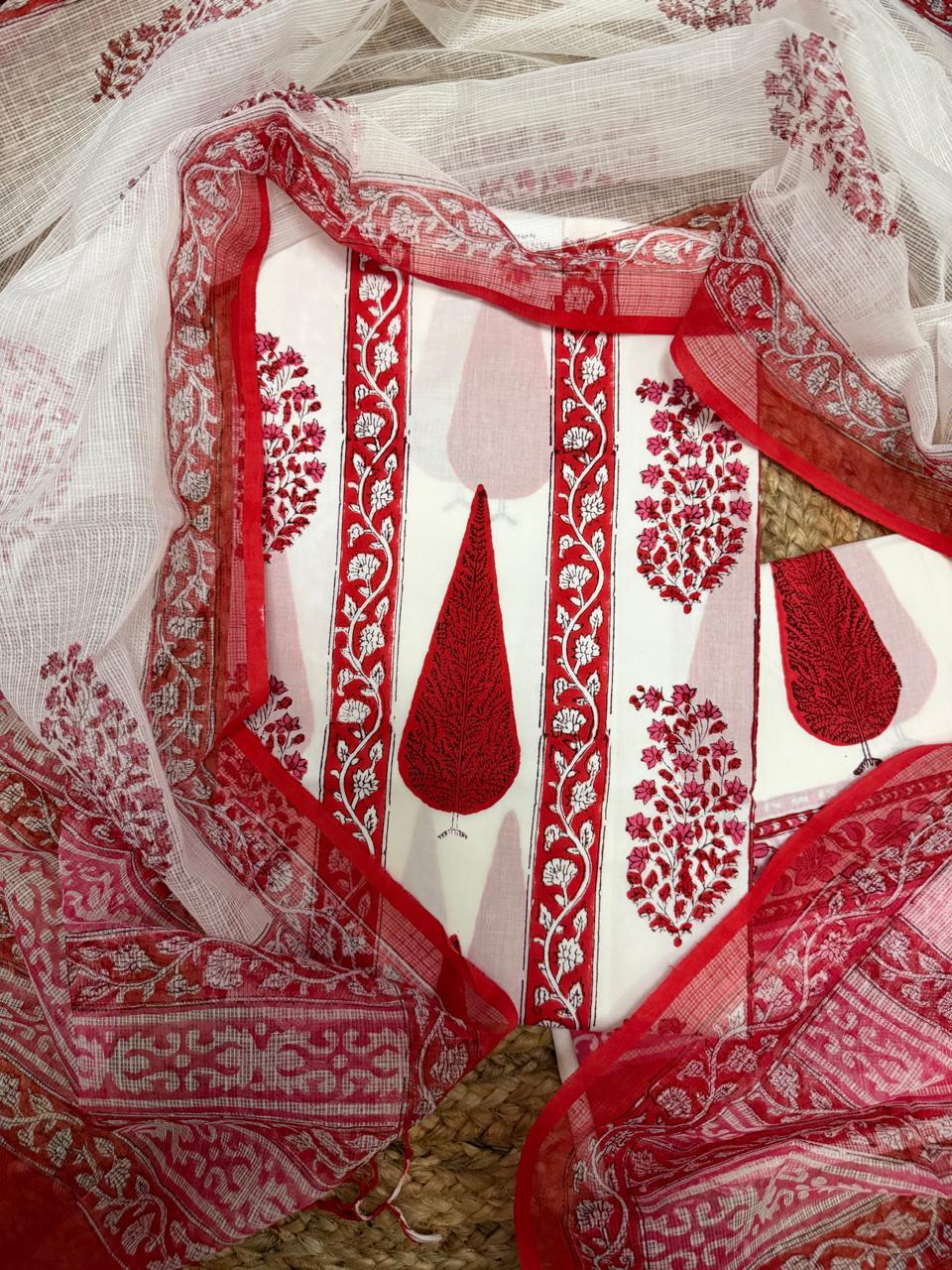 Overhead flatlay of white cotton placement block print unstitched kurta – large red paisley teardrop motifs with red floral vine border strips, sheer Kota Doria dupatta with red floral border and diamond weave fully spread around