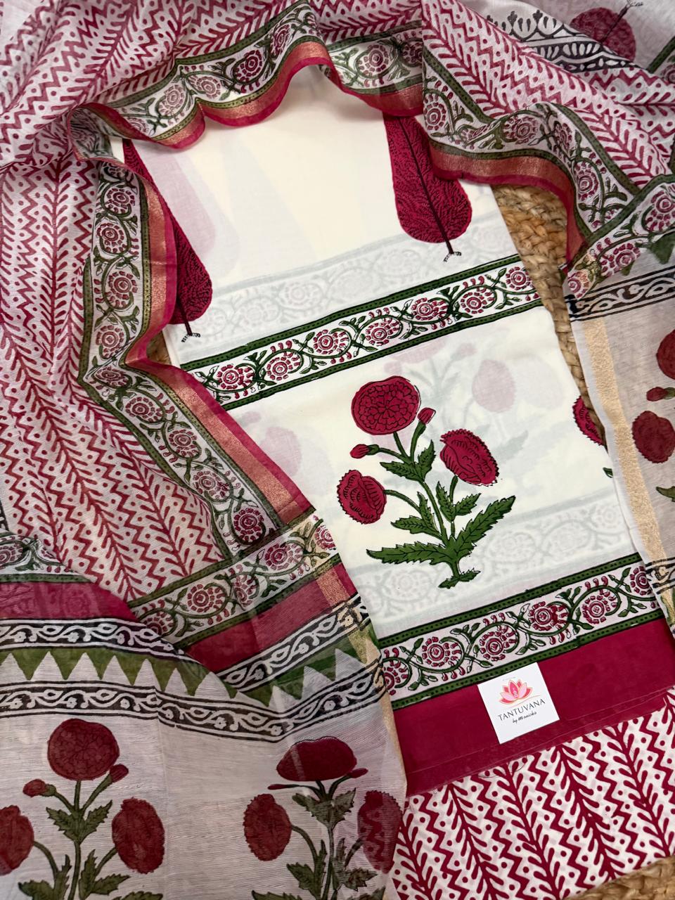overhead flatlay, kurta panel centred with large red poppy placement print, green floral vine border strip, Chanderi dupatta with red chevron and floral border draped around
