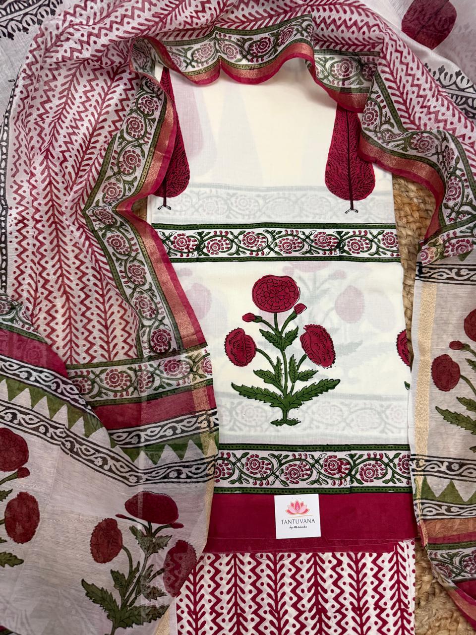 Overhead flatlay of white cotton placement block print unstitched kurta – large red poppy flower with green leaves, green floral vine and red geometric border strips, Chanderi silk dupatta with red chevron and floral border fully spread around