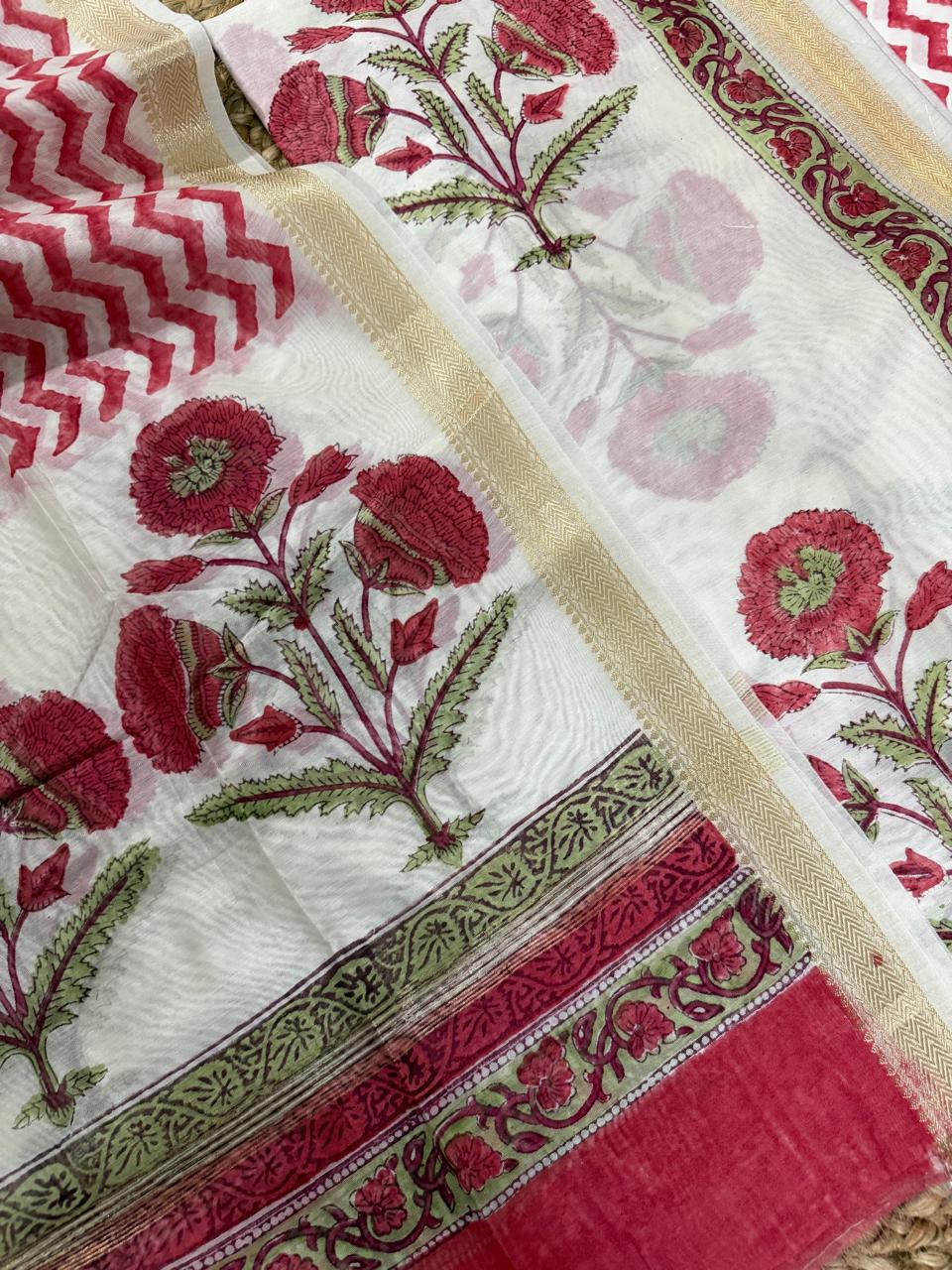 Close-up of white cotton Mughal block print kurta fabric – large red marigold floral motifs with green leaves, gold zari border strip and red chevron dupatta, unstitched suit set detail