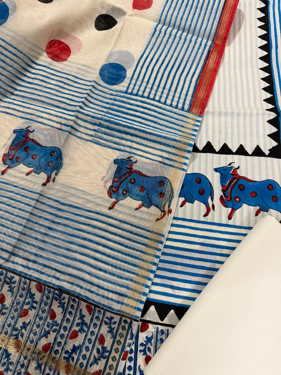 Angled close-up of white cotton Pichwai placement block print kurta – blue decorated cow motifs on blue horizontal stripe body with red border strip, alongside sheer Chanderi dupatta with blue stripe and red border, and blue floral butti bottom fabric