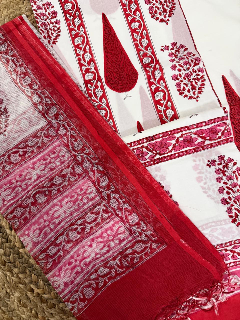 Angled flatlay of white cotton placement block print kurta – large red paisley teardrop motifs with red floral vine border strips, alongside sheer Kota Doria dupatta showing red floral butti body and red floral vine border