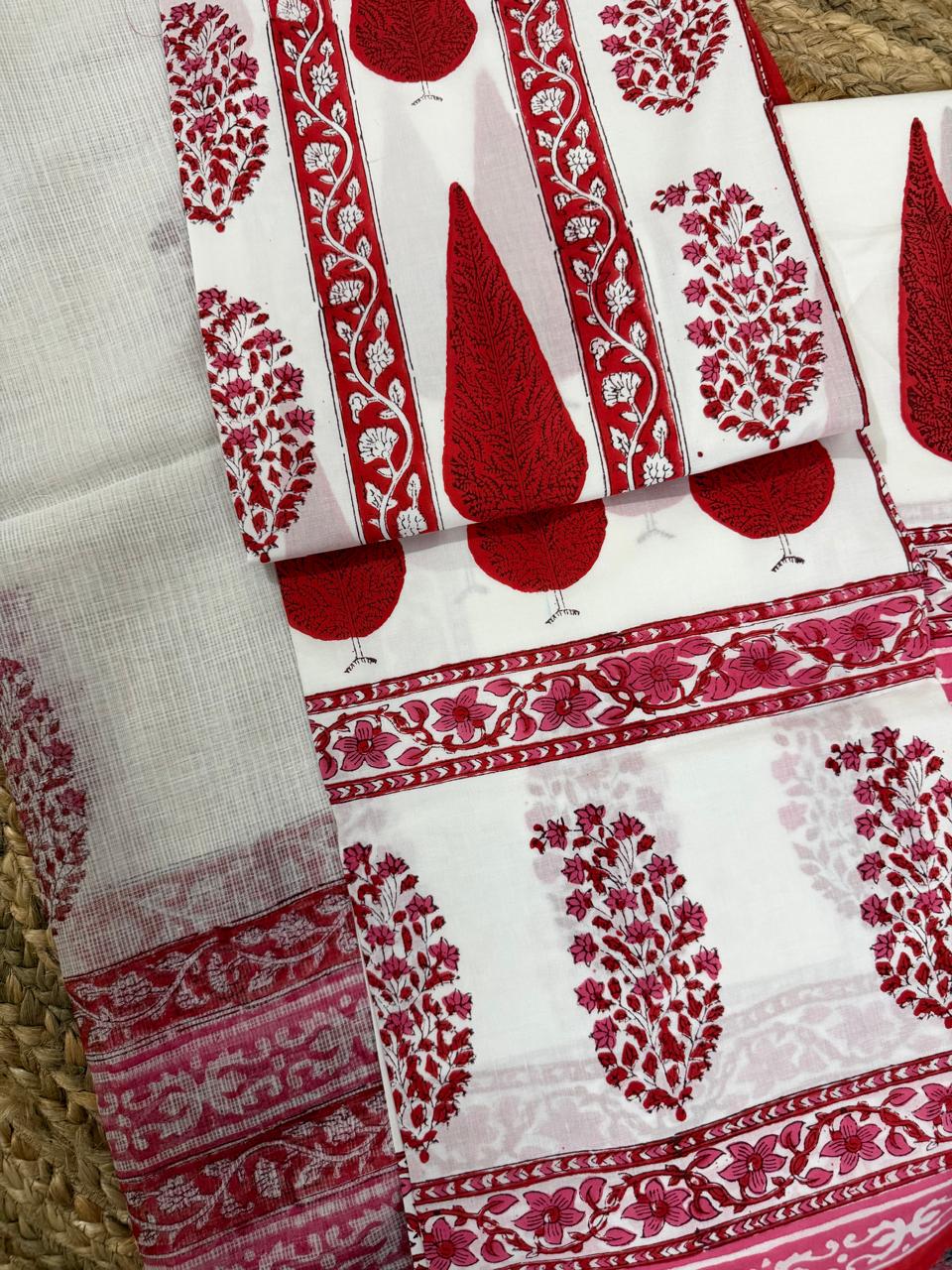Straight flatlay of white cotton placement block print kurta and bottom fabric – large red paisley teardrop motifs with red floral vine border strips on kurta, pink floral bottom fabric and sheer Kota Doria dupatta with red border 