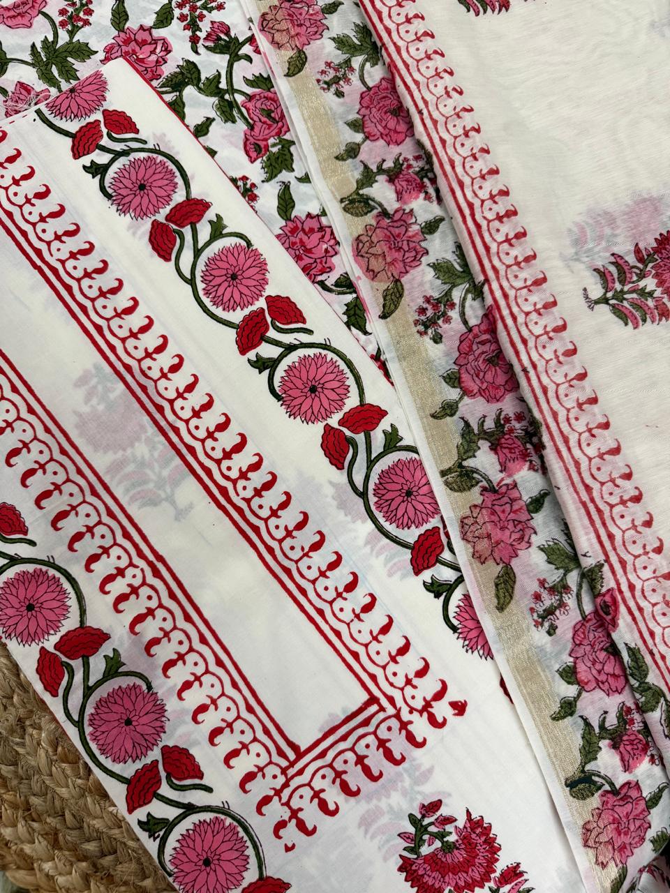 Close-up of white cotton placement block print kurta border – pink dahlia and red tulip vine with red scallop edge strip, alongside sheer Chanderi silk dupatta showing pink rose and green leaf all-over print with gold border