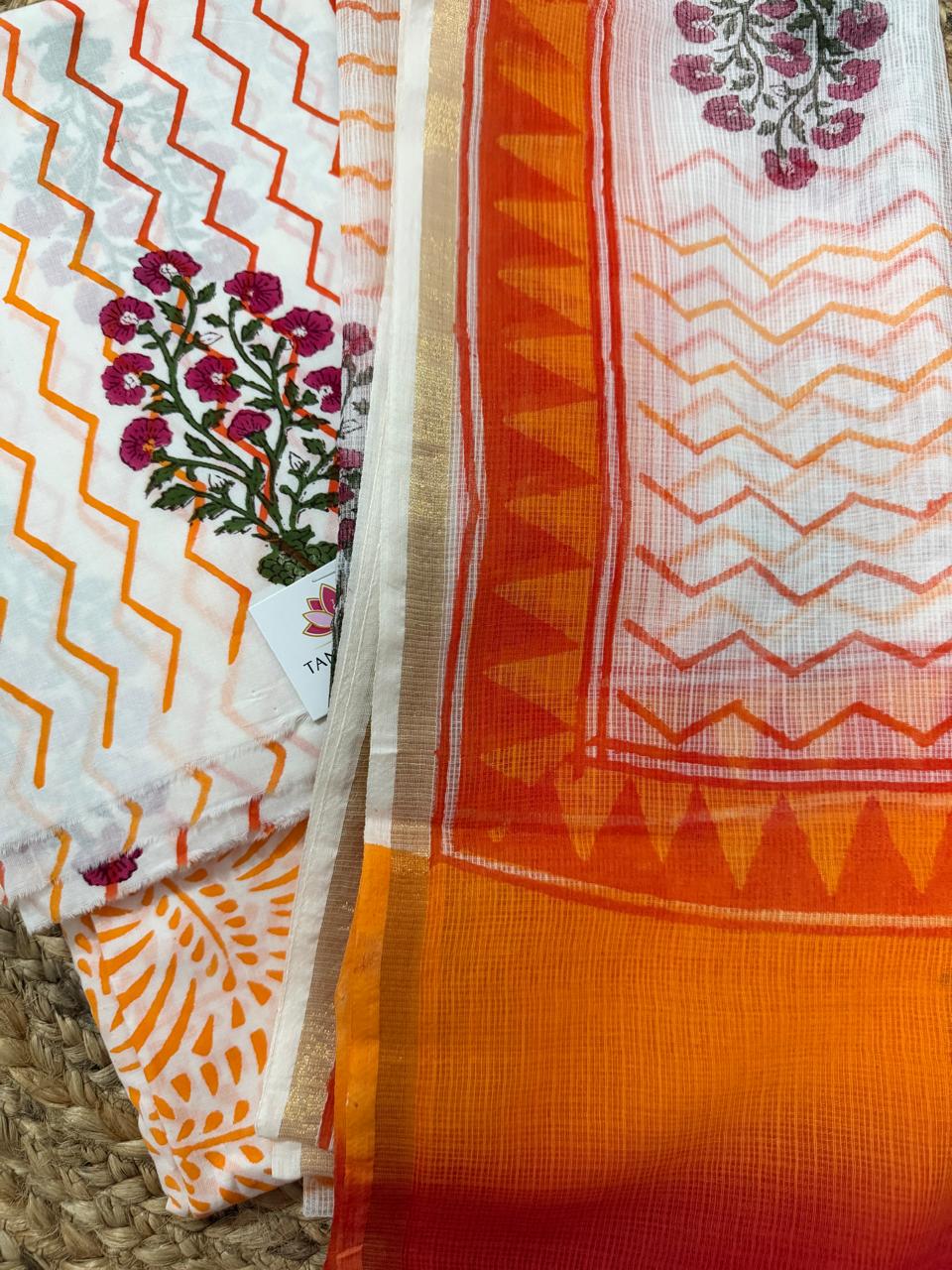 Angled close-up of white cotton Mughal block print kurta – orange zigzag chevron with pink floral butti, paired with sheer Kota Doria dupatta showing orange chevron print and solid orange border with gold zari
