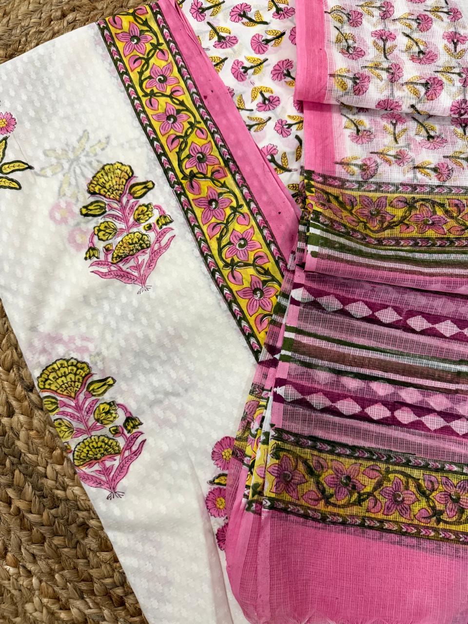 Angled close-up of white cotton Mughal block print kurta – pink and yellow marigold floral butti with yellow floral vine border strip, alongside sheer Kota Doria dupatta showing pink floral butti and pink-olive stripe weave border
