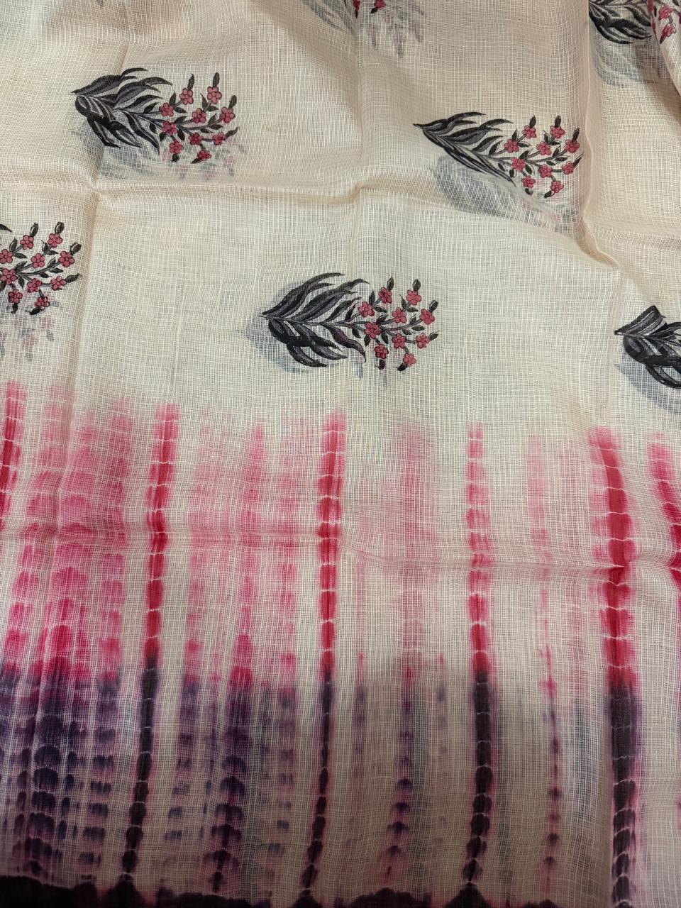 Close-up flat lay of off-white Kota Doria dupatta fabric with black floral block print motifs and gradient shibori-dyed border transitioning from pink to deep purple