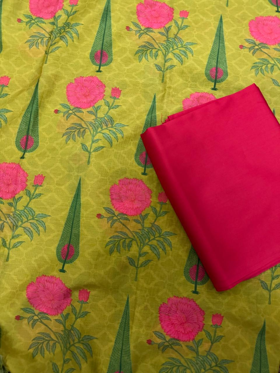 Flat lay of lime green Malai Chanderi silk unstitched co-ord set showing kurta fabric with pink peony and green cypress block print alongside folded solid hot pink bottom fabric