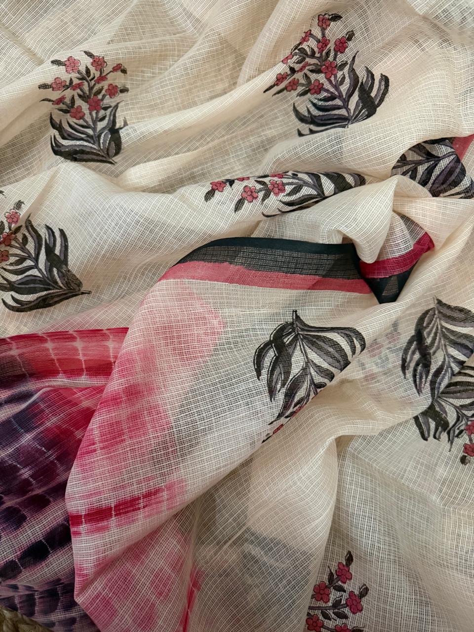 Draped close-up of off-white Kota Doria dupatta showing black floral block print, pink and black woven border stripe, and shibori-dyed pink to deep purple