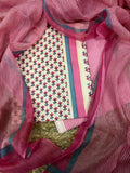 Overhead flat lay of cream and pink cotton block print 3-piece unstitched suit set with pink striped Kota Doria dupatta draped around, showing pink floral block print kurta fabric, striped bottom, and teal-pink border