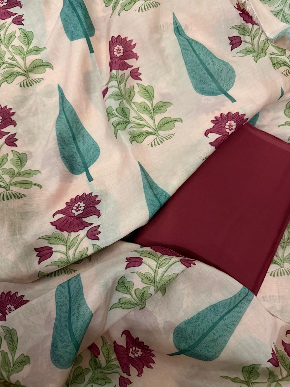 Draped flat lay of cream Malai Chanderi silk kurta fabric with teal cypress leaf and plum floral block print, paired with folded solid plum Malai Chanderi bottom fabric
