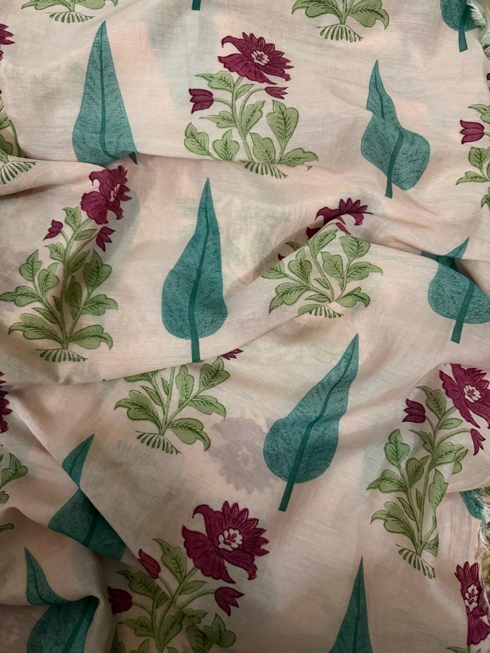 Close-up draped detail of cream Malai Chanderi silk kurta fabric showing teal cypress leaf motifs and plum floral bouquet block print with green foliage, highlighting the subtle shimmer of the silk weave
