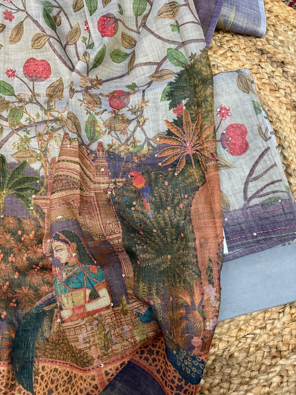 Grey gold Mughal print jute linen suit set – draped flat lay on rattan showing pomegranate tree digital print kurta, Mughal palace scene dupatta with royal lady and peacock motifs, purple kantha sequin border, and powder blue bottom fabric