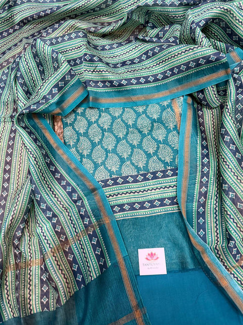 Teal and navy Chanderi silk 3-piece unstitched suit set – draped flat lay showing teal Chanderi kurta with white paisley booti print and navy diamond zigzag border, navy-green geometric stripe dupatta with gold zari selvedge, plain teal Chanderi bottom